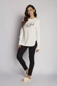 Modelo vestindo o Pijama Feminino Pretty Good da Sonno Blu, composto por blusa cinza com fenda lateral e calça preta.